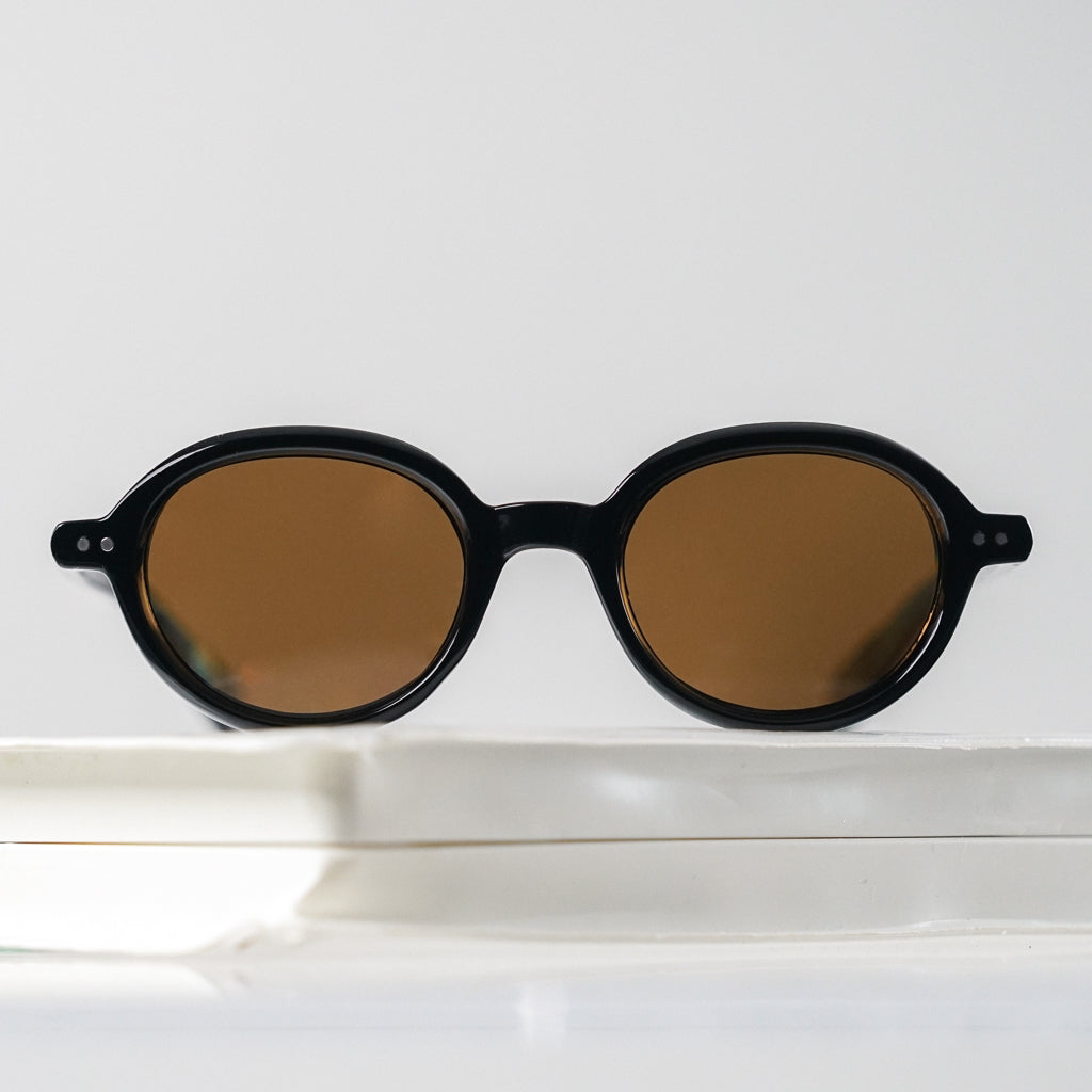 Ribotti Remake Léon Mathilda unisex sunglasses - timeless minimalist 90s style, round black frame, brown tinted lenses 