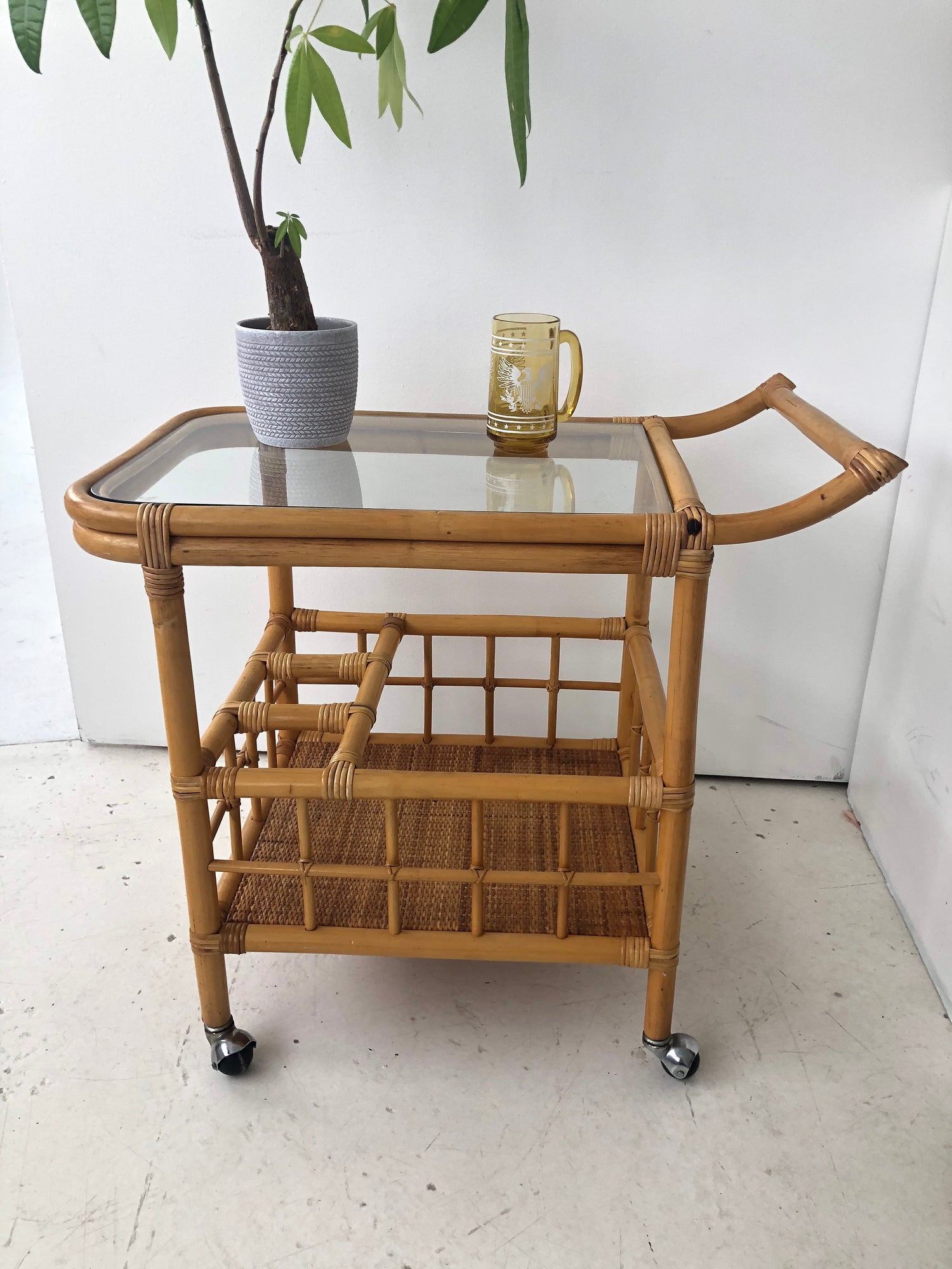Vintage bamboo wheeled bar cart with glass top