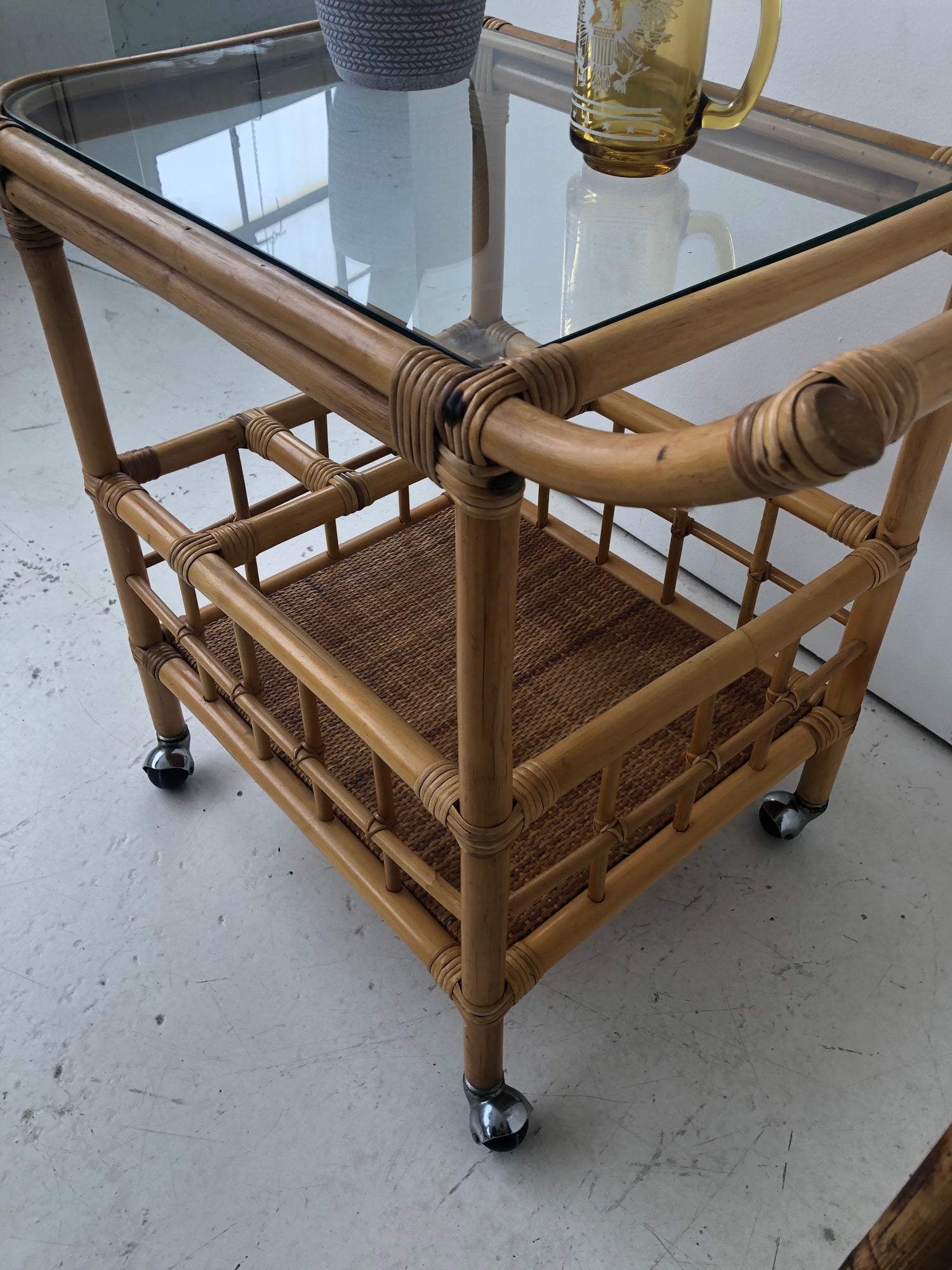 Vintage bamboo wheeled bar cart with glass top